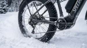 Close-up illustration of wide fat tires providing grip while riding an electric bike in deep snow.