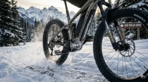 Close-up of a dual-suspension system handling icy, rutted terrain on a winter electric mountain bike.