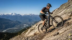 A photorealistic 4K photograph of a mountain biker mid-climb on an extremely steep, technical uphill trail, showcasing the power and capability of a trail e-bike in rugged Canadian terrain.