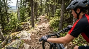 Alt text for image 3: A cyclist with a lightweight hardtail electric mountain bike pausing at a lookout point in Mont-Tremblant, Quebec, overlooking a vast landscape of vibrant red and orange autumn maple leaves and rolling hills.