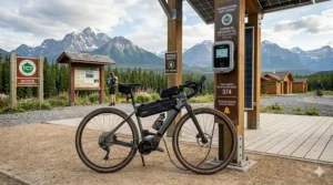A gravel ebike plugged into a charging station in a small Canadian trail town, highlighting infrastructure for long-distance e-touring.