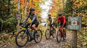 A diverse group of Canadian cyclists on gravel ebikes riding through a vibrant Laurentian forest in Quebec.