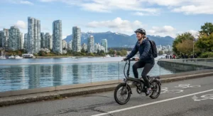 A commuter riding a folding e-bike for city commuting with the Vancouver skyline in the background.