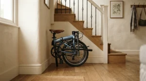 A compact folding e-bike for small storage spaces resting on a multi-family townhouse staircase landing.