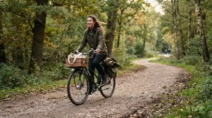A rider navigating a gravel park path on a hybrid e-bike for commuting to work through falling leaves.
